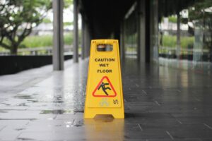 yellow Caution wet floor signage on wet pavement